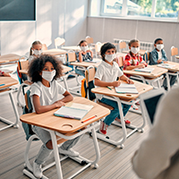 Elementary school students sitting in class with masks